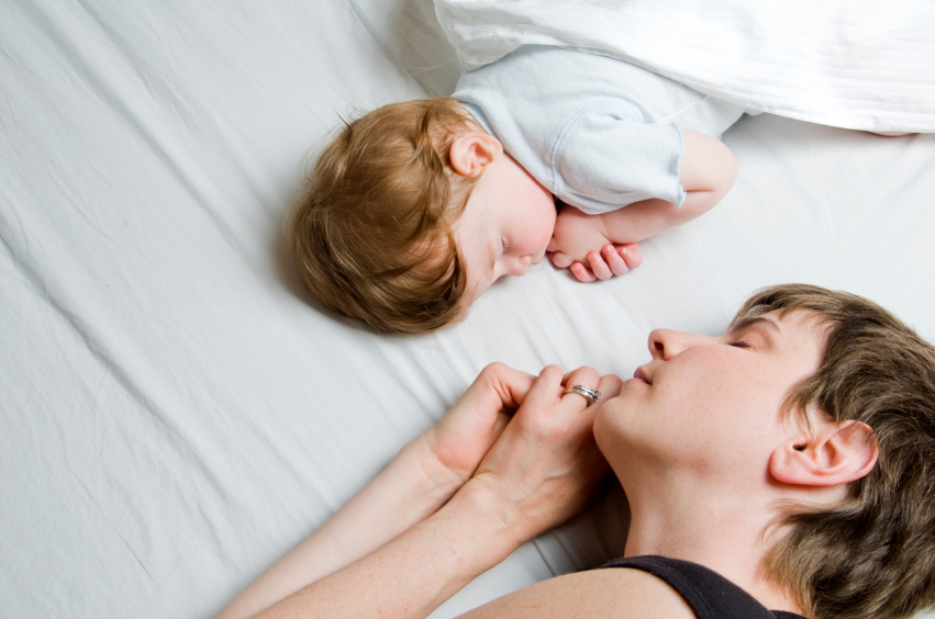 Kind und Mutter schlafen im Bett, Ansicht von oben