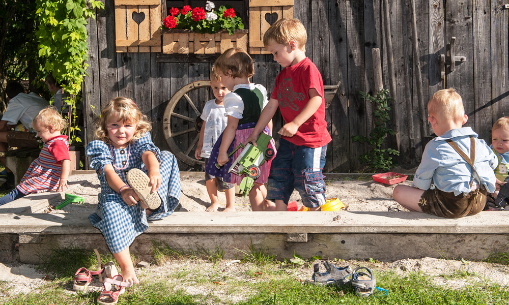 Kinder in der Sandkiste auf dem Bauerhof